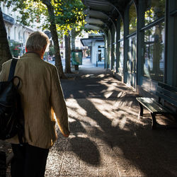 Rear view of woman walking on sidewalk