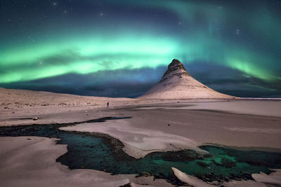 Scenic view of snowcapped mountains against sky at night