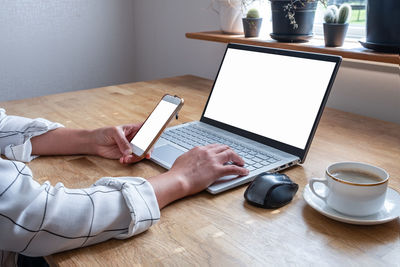 Midsection of man using mobile phone on table