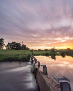 Scenic view of river against sky at sunset