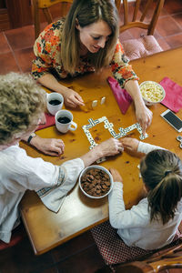 High angle view of family playing dominos at table