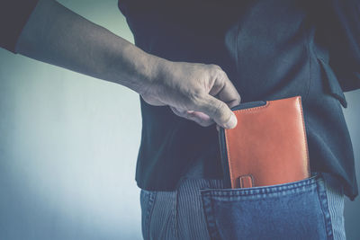 Cropped hand burglar removing wallet from man pocket