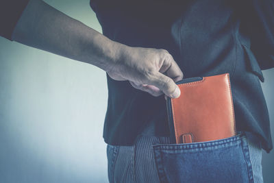 Cropped hand burglar removing wallet from man pocket