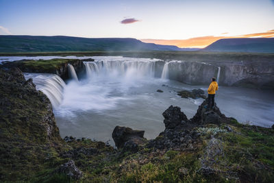 Scenic view of waterfall against sky