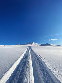 Scenic view of snowcapped landscape against blue sky