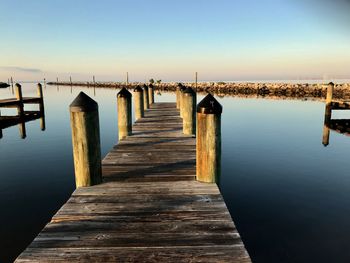 Wooden pier over lake against clear sky