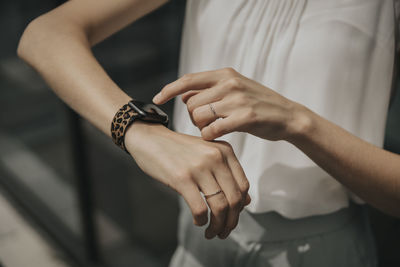 Young woman touching smart watch on sunny day