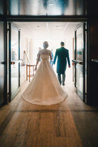 Rear view of couple walking in corridor