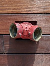 High angle view of metal pipe on wooden wall