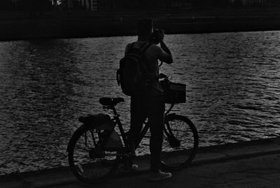 Side view of man riding bicycle on water