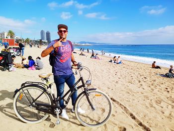 Portrait of man with bicycle on beach