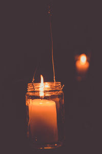 Close-up of illuminated candle against black background