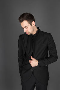 Young man looking away against gray background