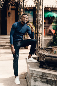 Full length portrait of young man standing on land in city