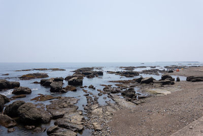 Rocks on beach against clear sky