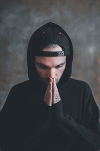 Young man with hands clasped 