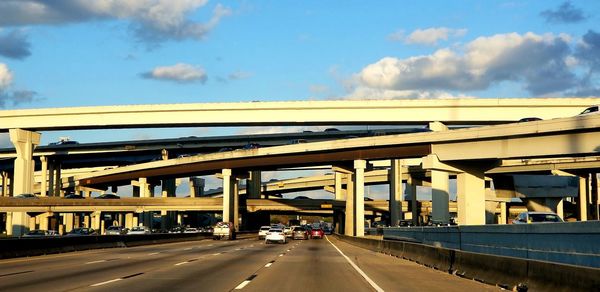 Bridge over highway in city against sky