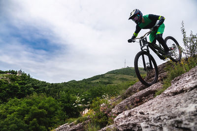 Sport. cyclist against the sky. a young man rides a mountain bike in beautiful nature.downhill, mtb