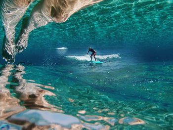 Double exposure of surfer and underwater reflection of legs