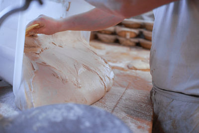 Midsection of baker preparing daugh 