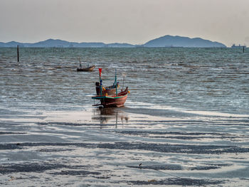 Boat moored on sea against sky