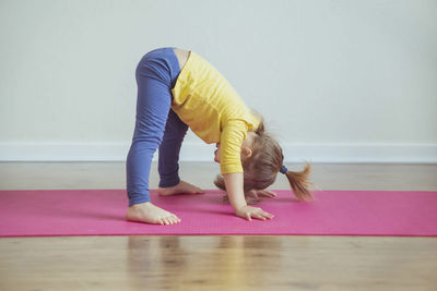 Charming baby doing yoga at home. place for text