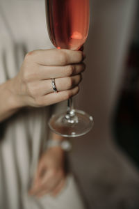 Midsection of woman holding wineglass