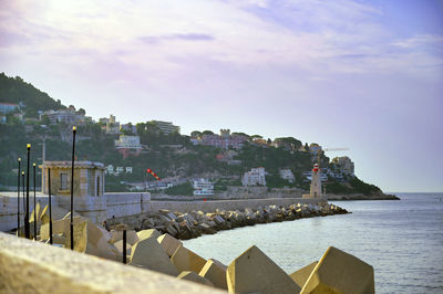 Scenic view of sea by buildings against sky