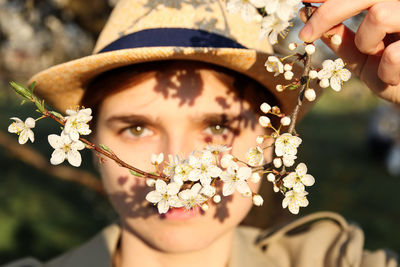 Woman with green eyes, cherry blossoms in spring, nature-inspired art. artistic capture of a woman