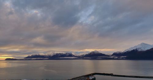 Scenic view of lake and mountains against sky during sunset