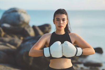 Portrait of young woman exercising at beach