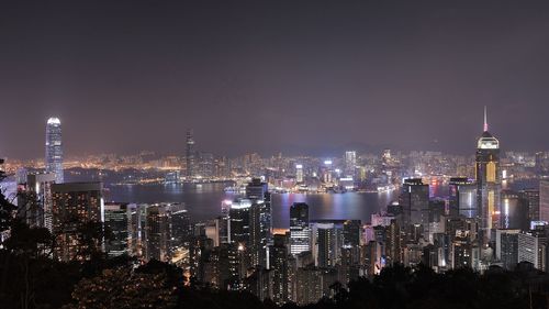 Illuminated cityscape against sky at night