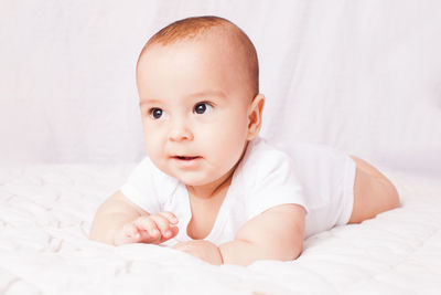 Portrait of cute baby lying on bed