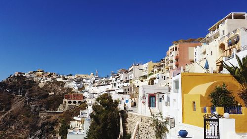 Buildings in town against clear blue sky