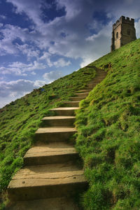 Low angle view of castle on hill against cloudy sky