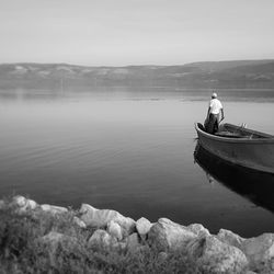 Man on boat in sea against sky