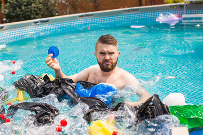 Portrait of shirtless man in swimming pool