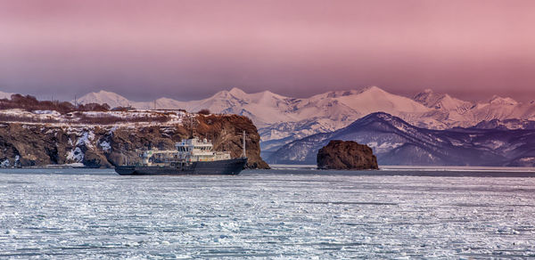 Hydrological vessel off the coast of the kamchatka peninsula in avacha bay at sunset