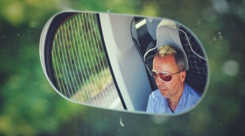 Reflection of man on mirror in car