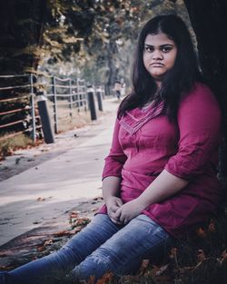 Portrait of young woman sitting outdoors