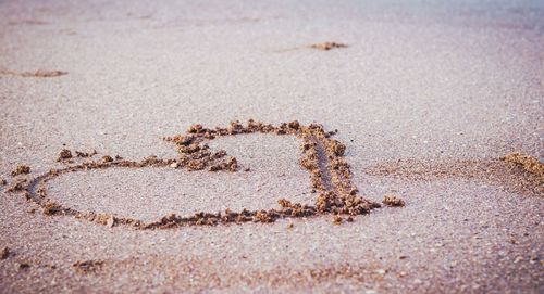 High angle view of heart shape on sand