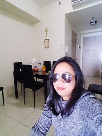 Portrait of woman in sunglasses at home