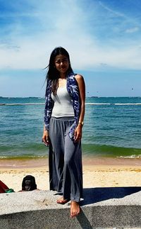 Portrait of smiling young woman standing on beach