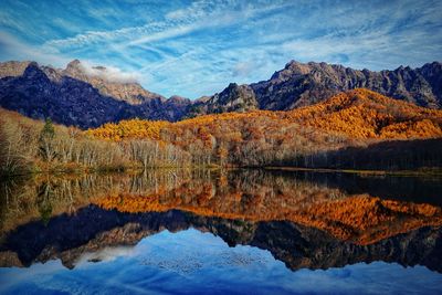 Scenic view of lake by mountains during autumn