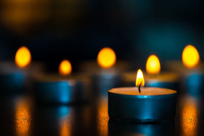 Close-up of illuminated tea light candles on table