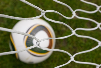 Close-up of barbed wire fence on field