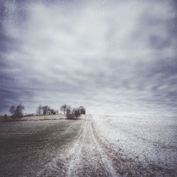 Road passing through landscape against cloudy sky