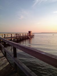 Pier over sea against sky during sunset