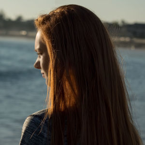 Close-up of woman standing against sea