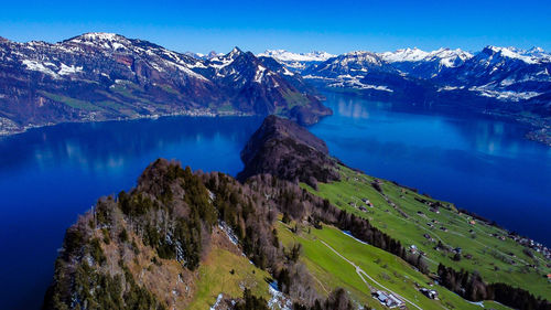 Scenic view of lake and mountains against blue sky